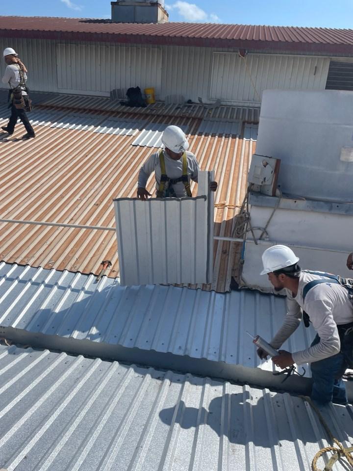 Metalguard workers replacing metal roof panels