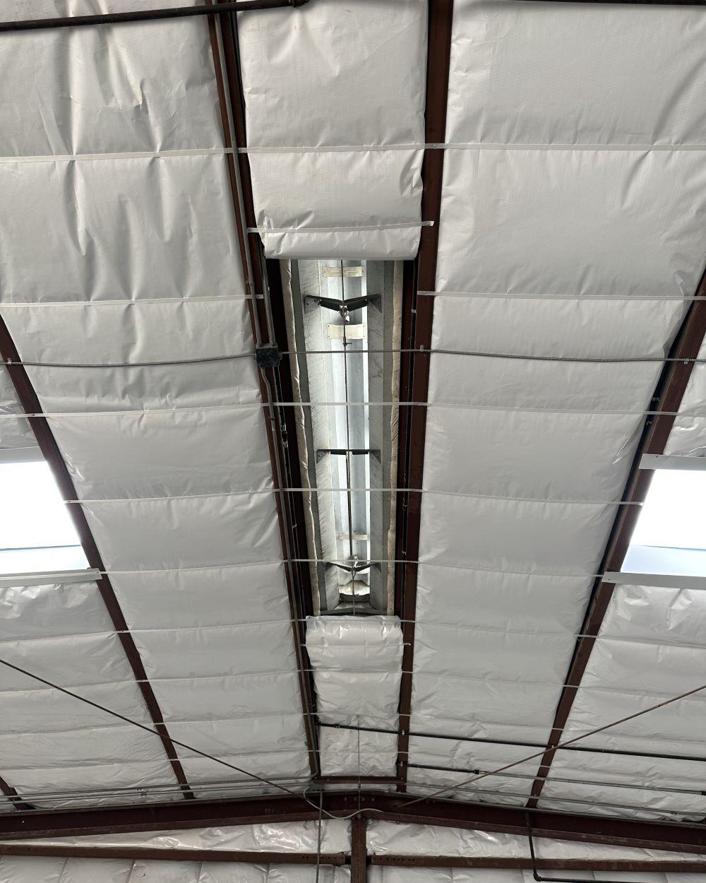 Metal roof insulation around ridgevent