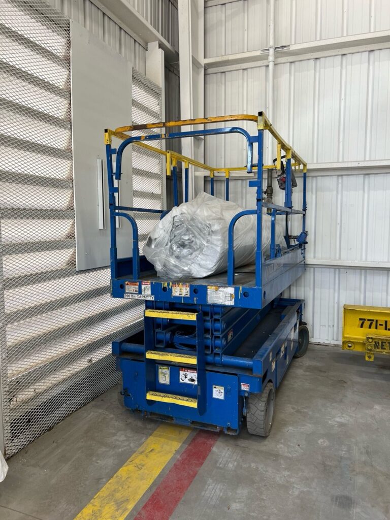 A Metalguard Scissor Lift with a roll of insulation.