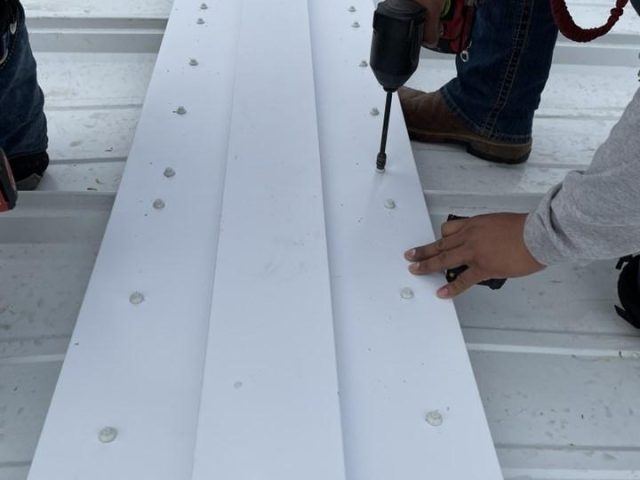 The ridge cap seams are sealed using two rows of caulk tape and urethane caulk.